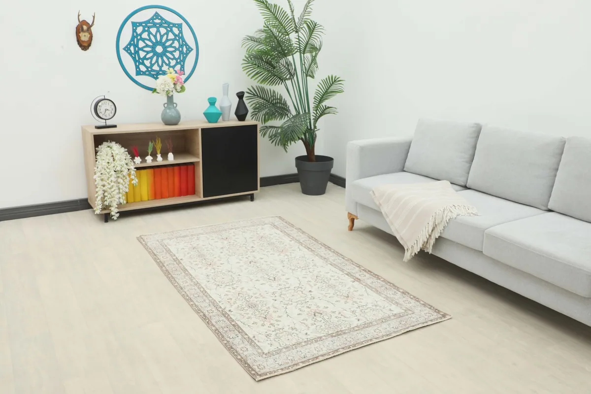 Vintage ivory beige rug displayed in a modern living room setting with a light gray sofa.
