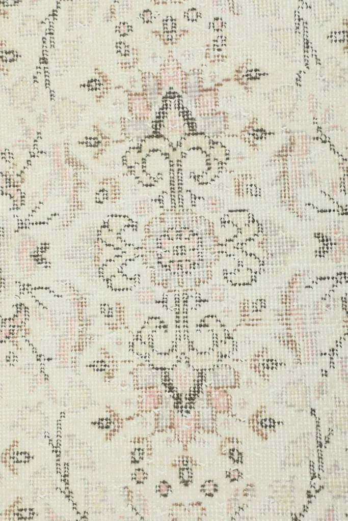 Close-up of a specific floral and geometric motif within the ivory field, showing color variations.