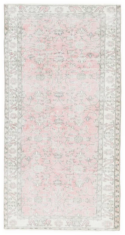 Full overhead view of the pink floral vintage Anatolian area rug on a white background.