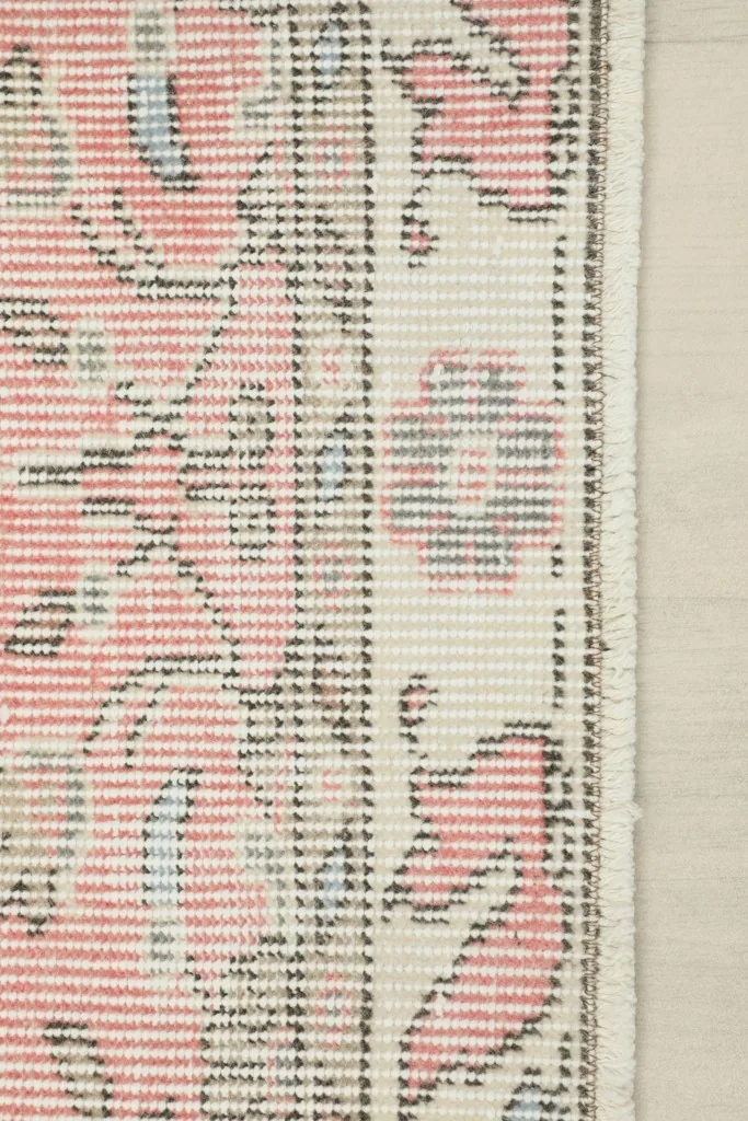 Close-up view of the rug's low pile and the edge, showing the texture and weave.