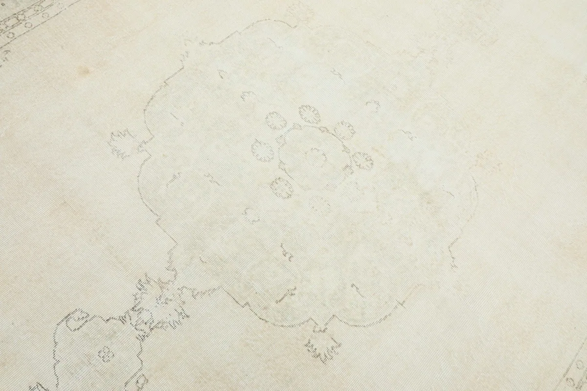 Close-up view of the central medallion design, showing its faded gray outline on the ivory background