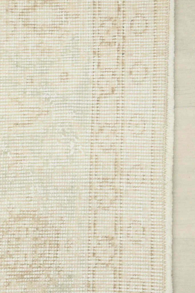 Close-up of the back of the hand-knotted rug, revealing the cotton foundation and tight weave