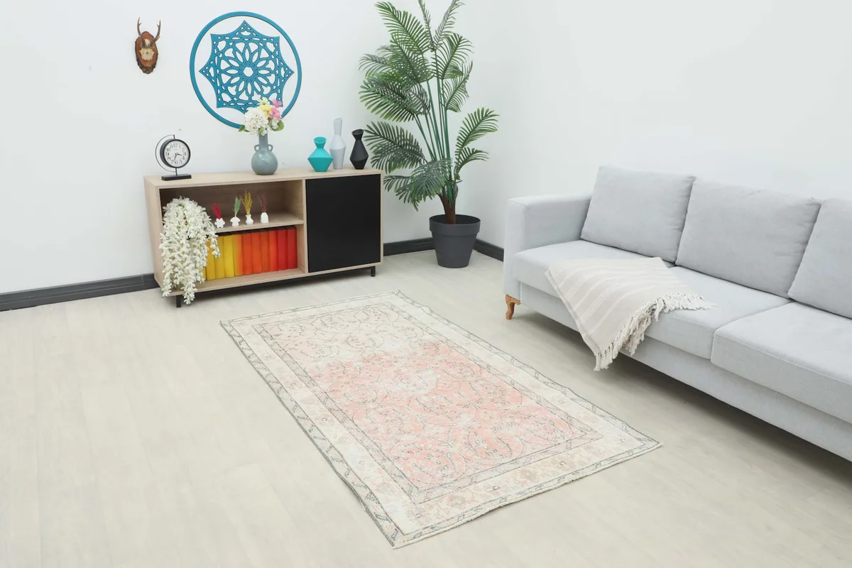 Vintage rose and ivory rug placed in a modern living room setting with a light gray couch