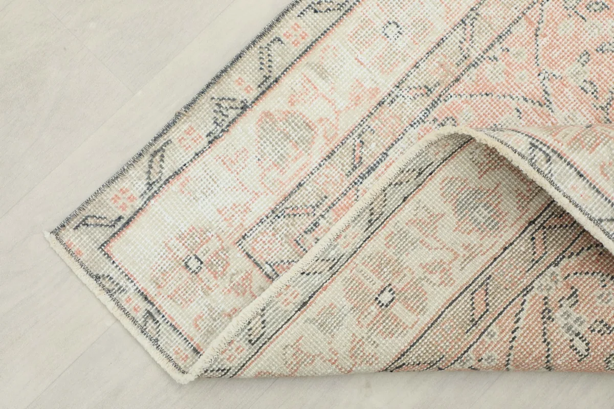 Corner of the rug folded back, displaying the thickness and quality of the wool pile