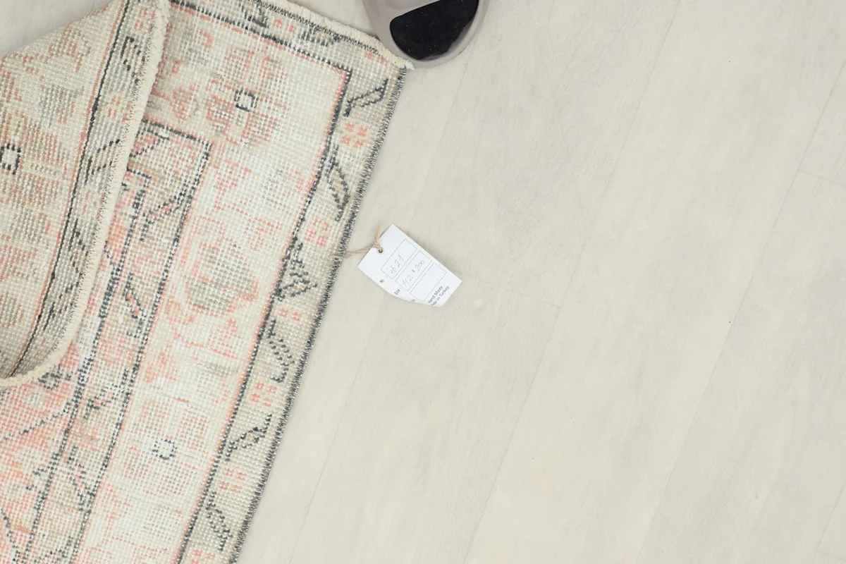 Overhead shot showing a corner of the rug with its product tag, indicating its authenticity