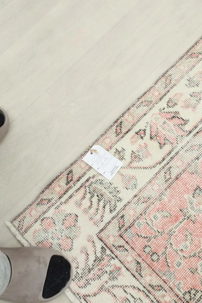 View of the rug's backside and a tag, showing the craftsmanship and material details.