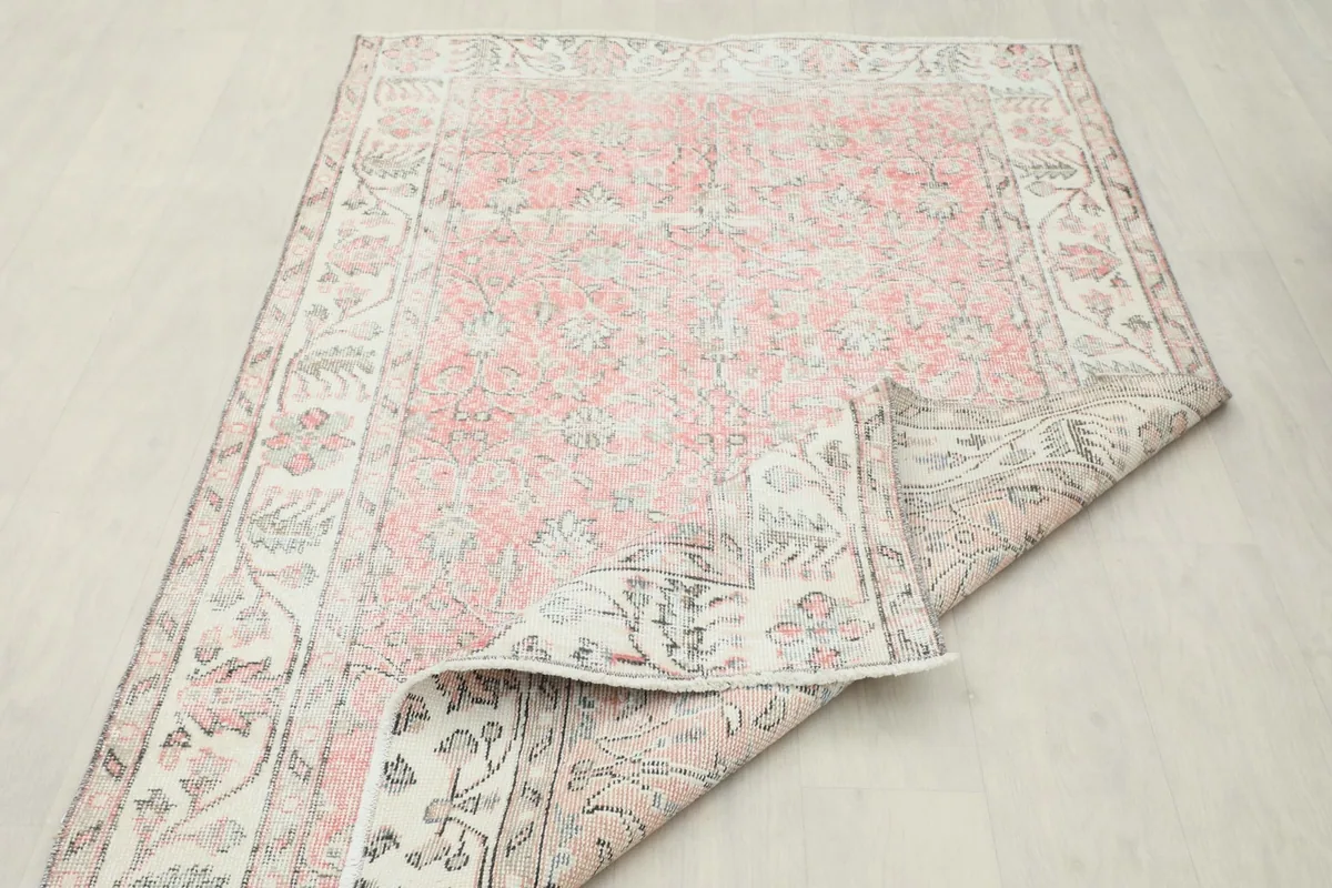 Larger section of the rug folded, showing the back of the rug and its overall construction.