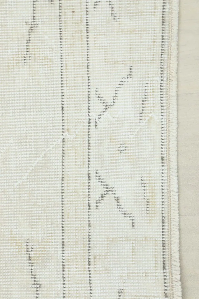 View of the back of the hand-knotted wool rug, revealing the cotton foundation
