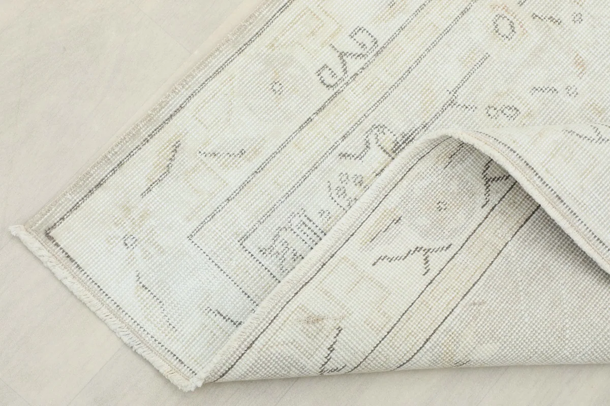 Corner of the rug folded back, showing the thickness and construction of the vintage piece
