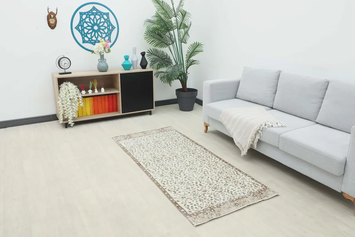 Ivory and brown runner rug placed in a modern living room setting next to a sofa