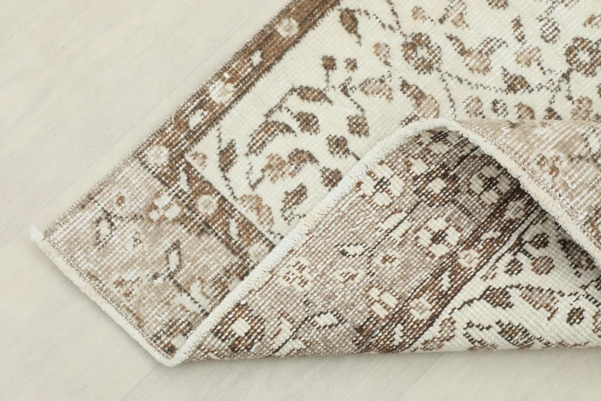 Corner of the runner folded to show the cotton foundation and rug thickness