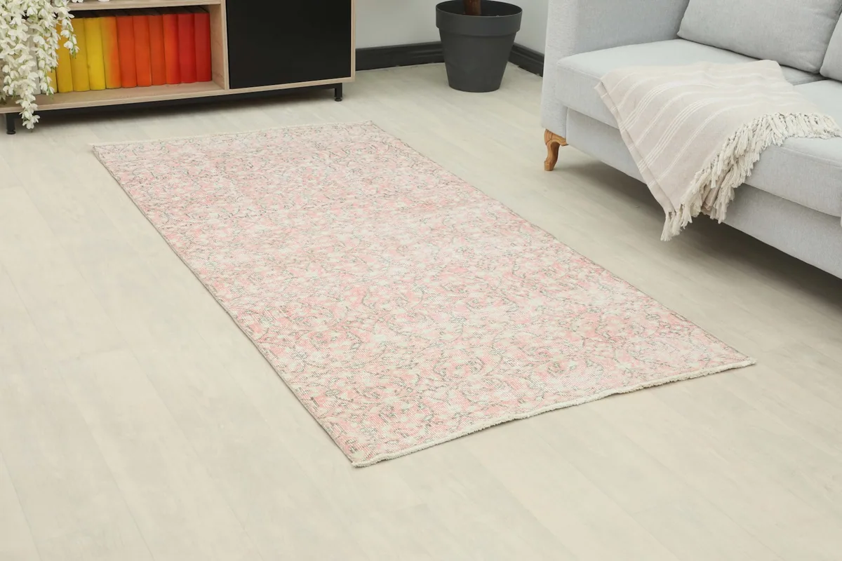 Angled view of the vintage Anatolian rug in a room setting, highlighting its colors and overall design.