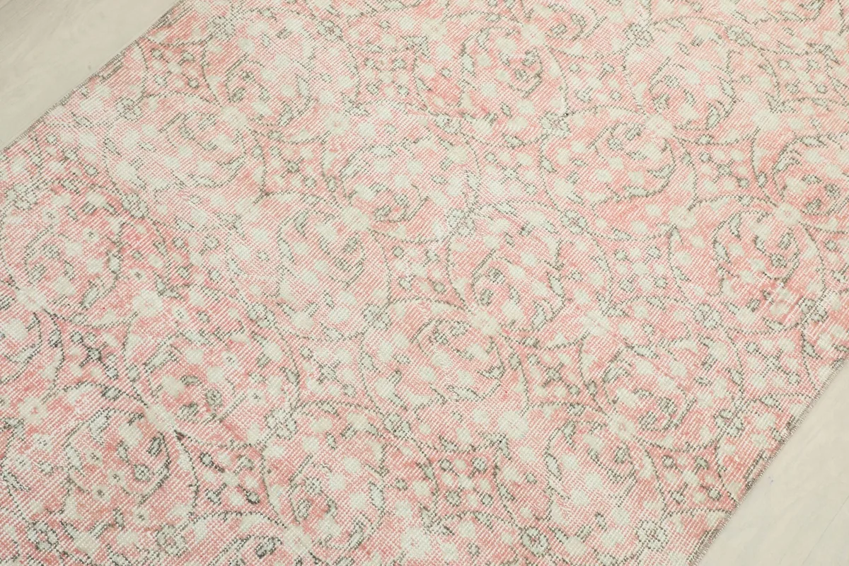 Overhead detail shot emphasizing the intricate, faded patterns and color variations within the pile.