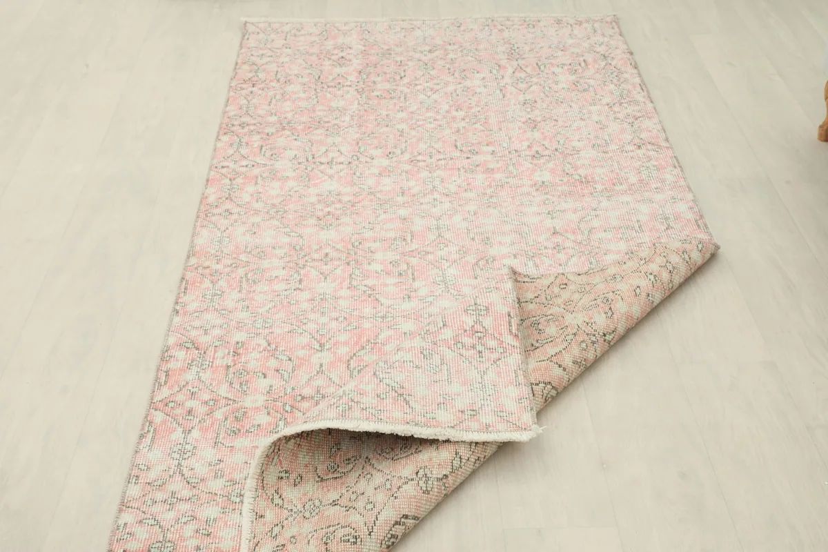 Partial view of the rug's back, revealing the tightly woven cotton foundation and craftsmanship.