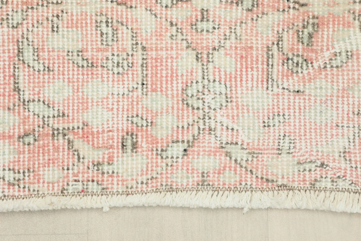 Detail of the rug's edge, showcasing the short, natural fringe and the finished border.