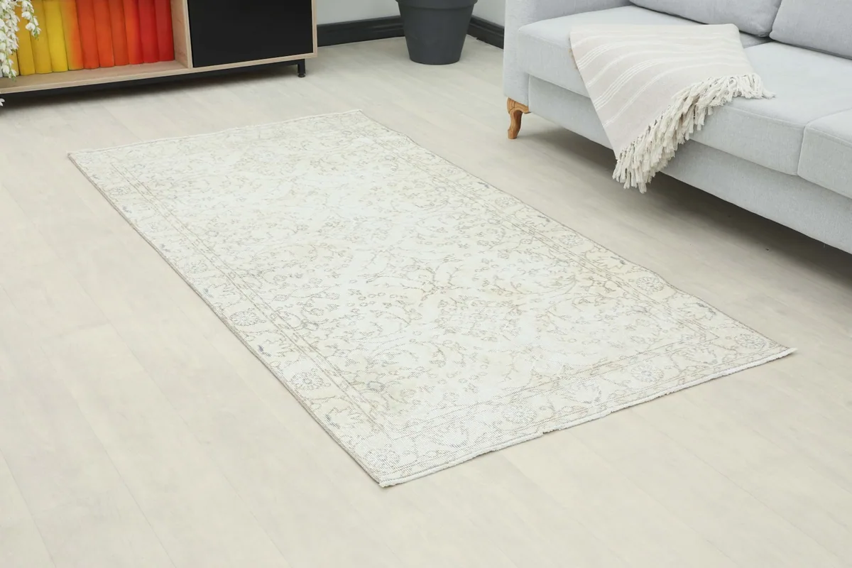 Overhead view of the beige rug in a living room, showing its placement relative to a sofa