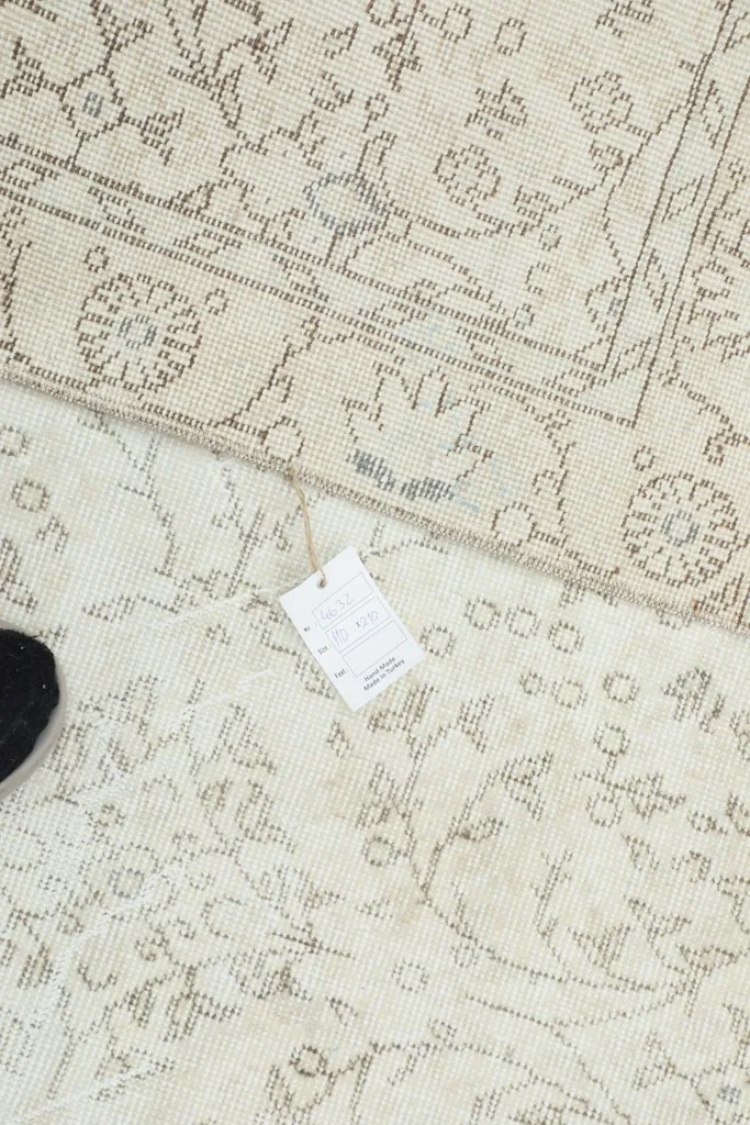 Close-up of the rug's back, showing the hand-knotted structure and material tag