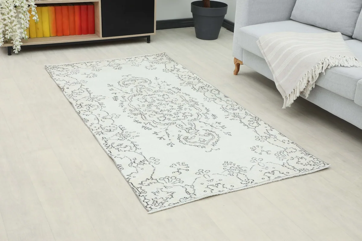 Angle view of the ivory and charcoal rug in a living room, highlighting its placement and overall design.
