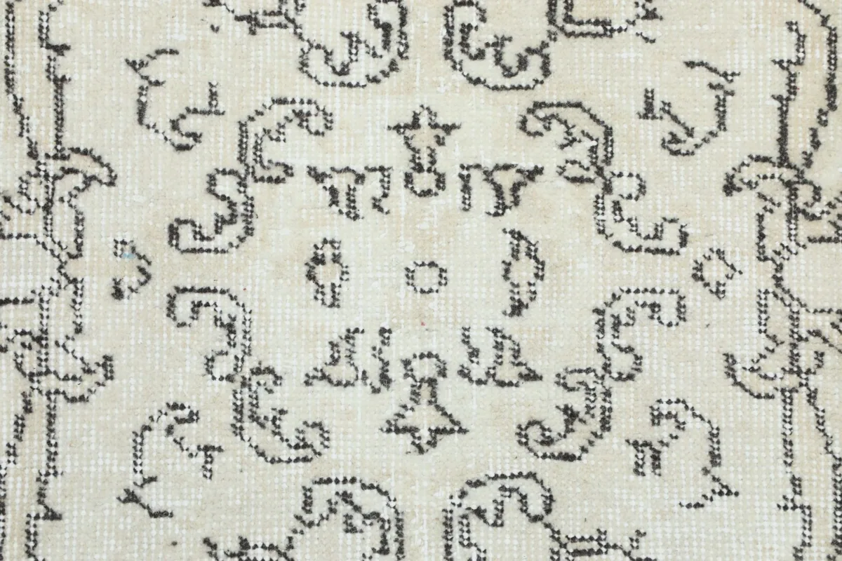 Detailed view of the charcoal patterns, showcasing the intricate hand-knotted craftsmanship and wool pile.
