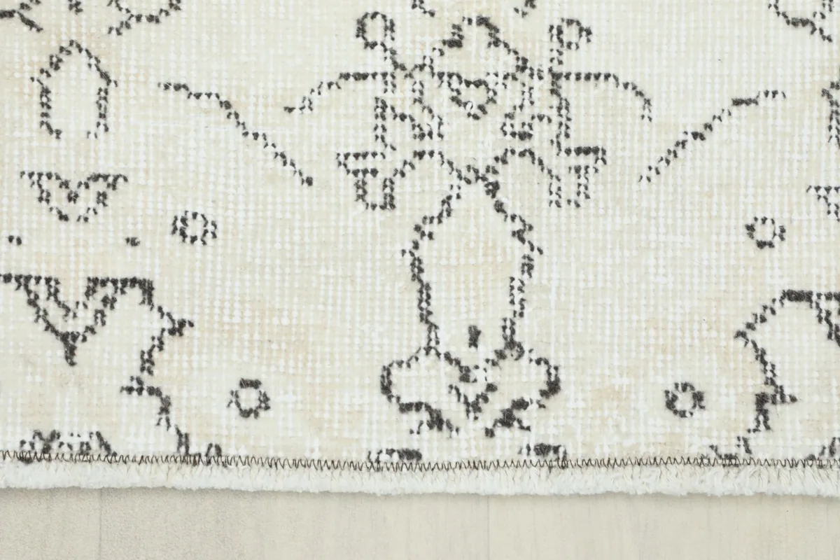Close-up of the rug's border and fringe, revealing the natural fiber and hand-finished edge.