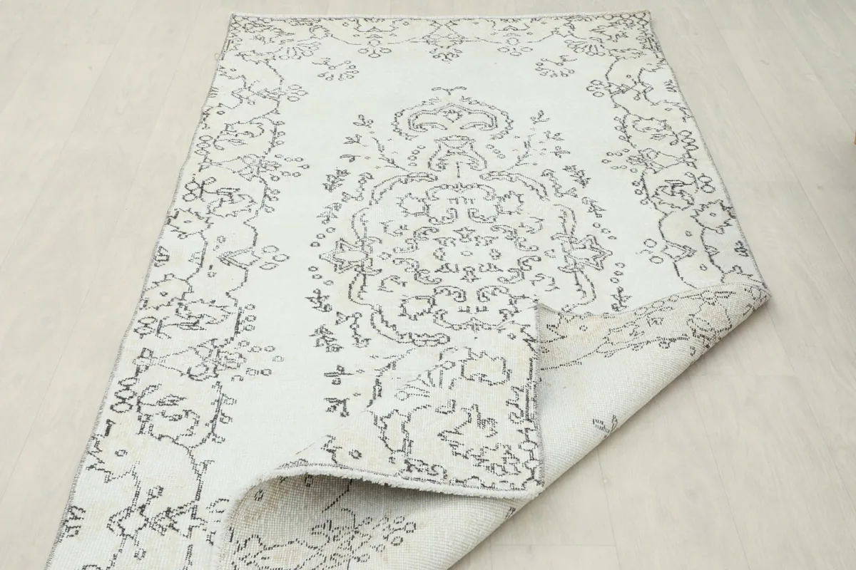 Partial fold of the rug, displaying the flexibility and the subtle color variation on the reverse.