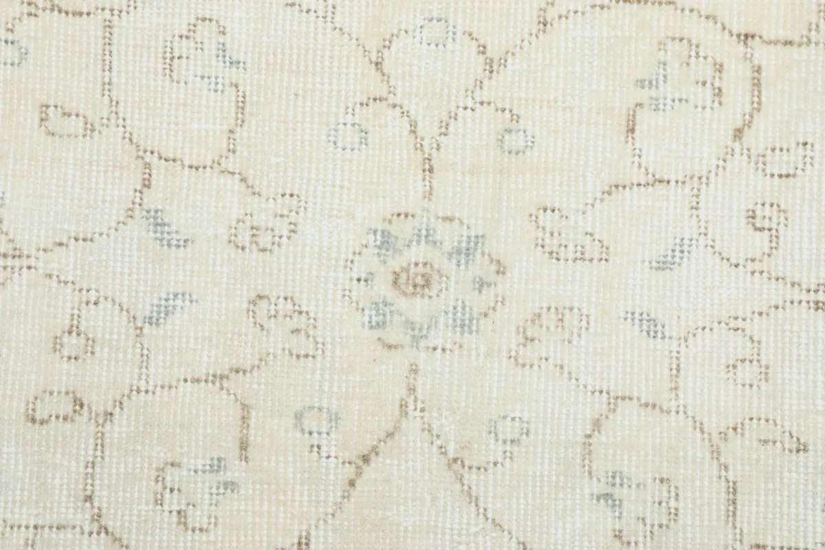 Extreme close-up of a central floral medallion motif with beige and blue accents