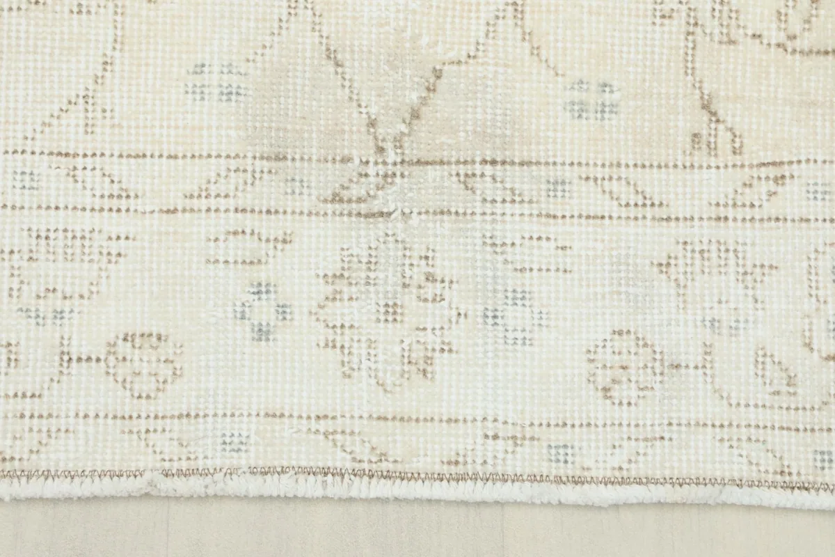 Close-up of the rug's edge, revealing the detailed border design and short fringe