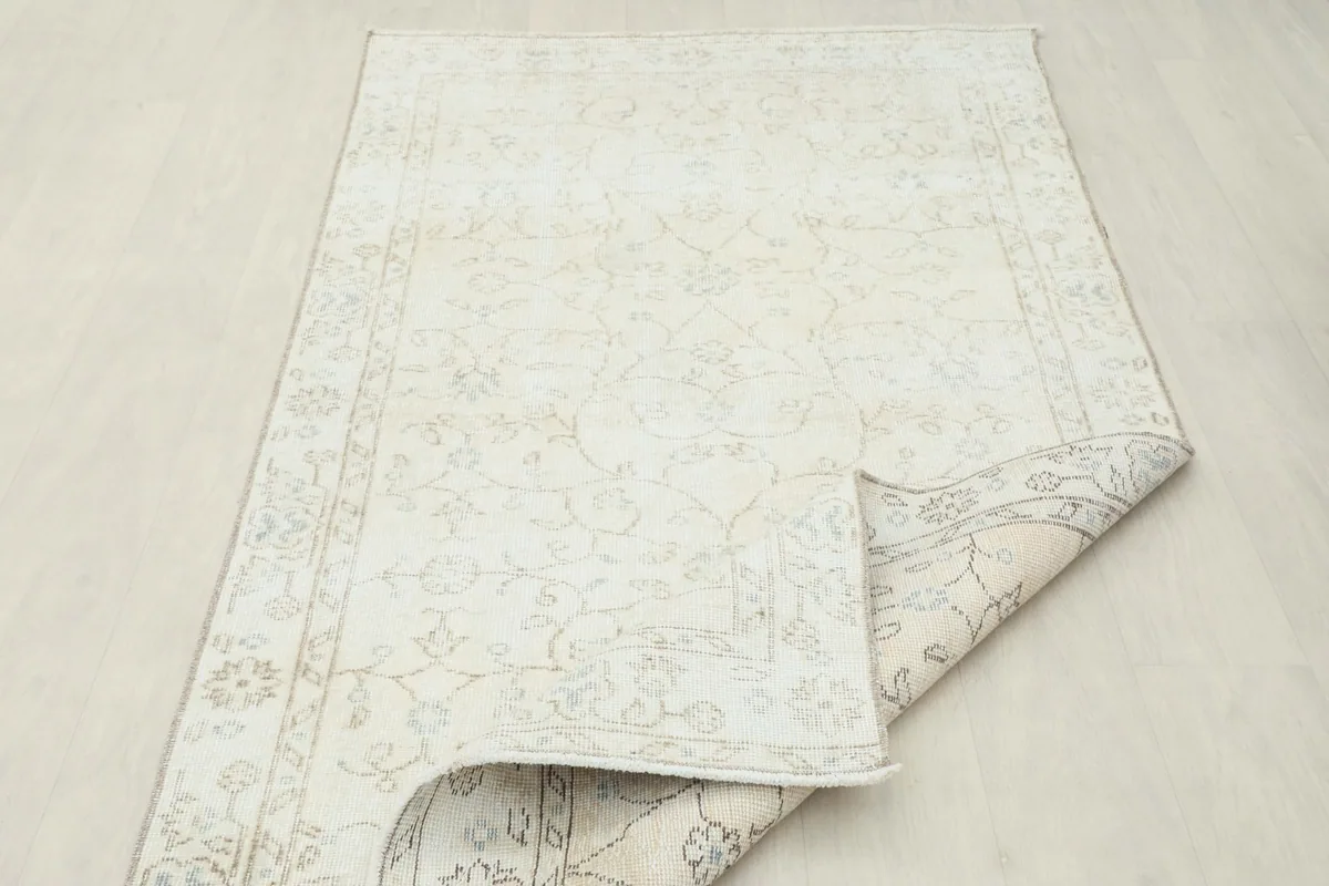 Rug partially folded, displaying the reverse side and the natural character of the wool