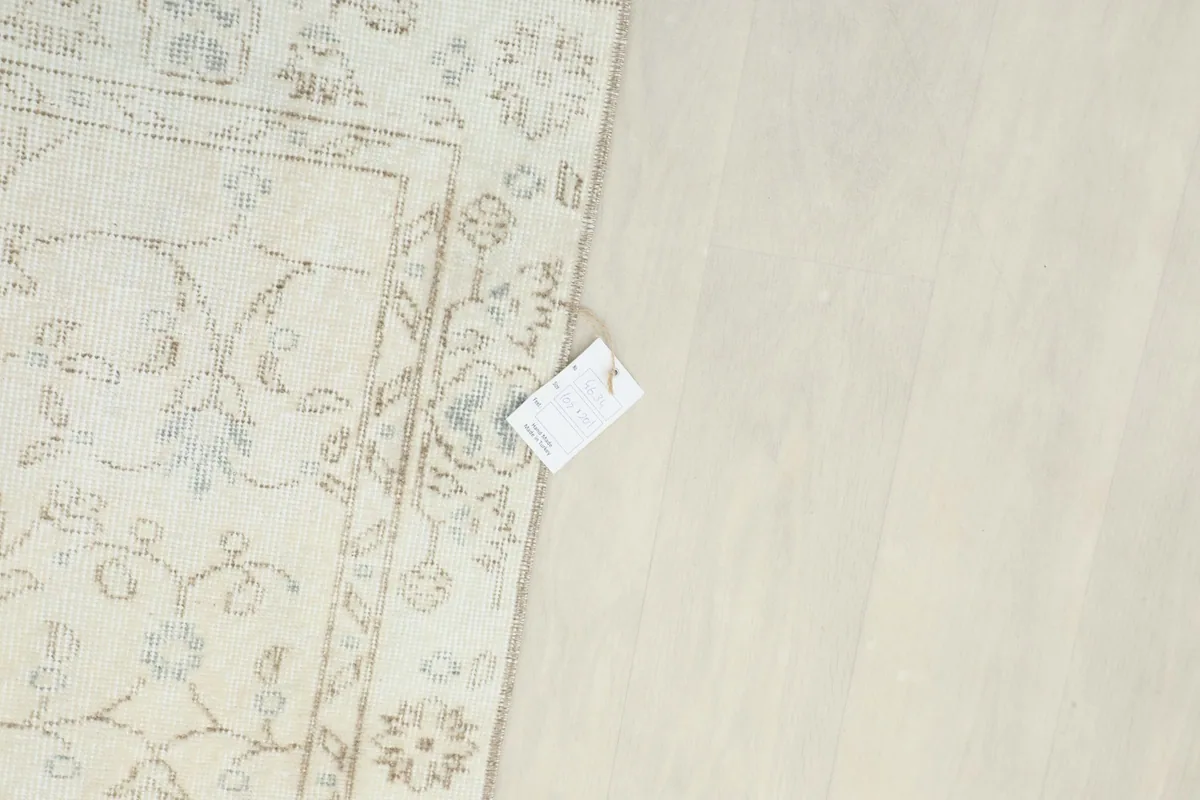 Top-down view of a small section of the rug with a size tag, showing texture and color