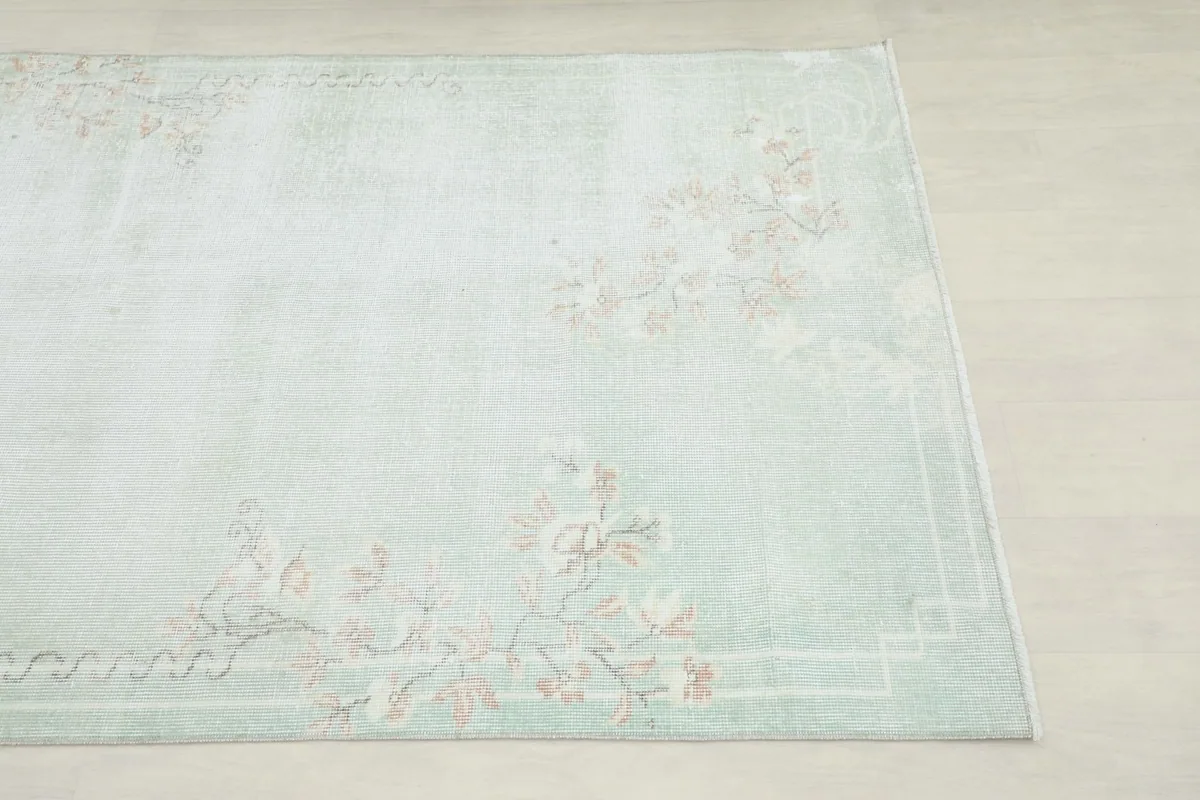 Close-up view of the rug's corner, highlighting the rose floral motif and subtle border design.