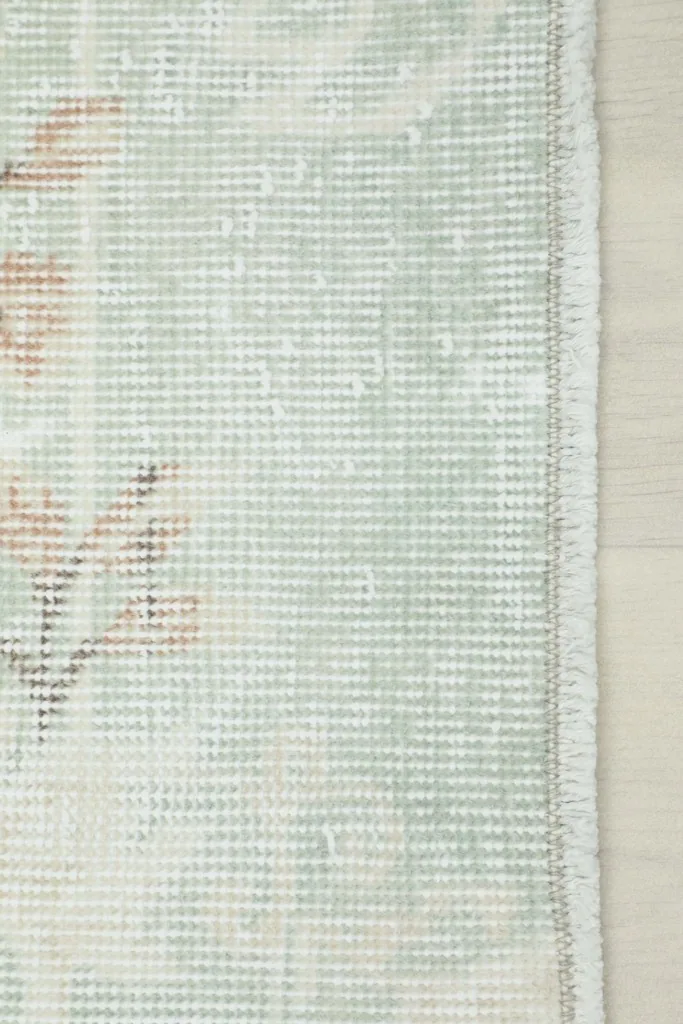 Detail of the rug's edge and fringe, showcasing the hand-finished quality and cotton foundation.