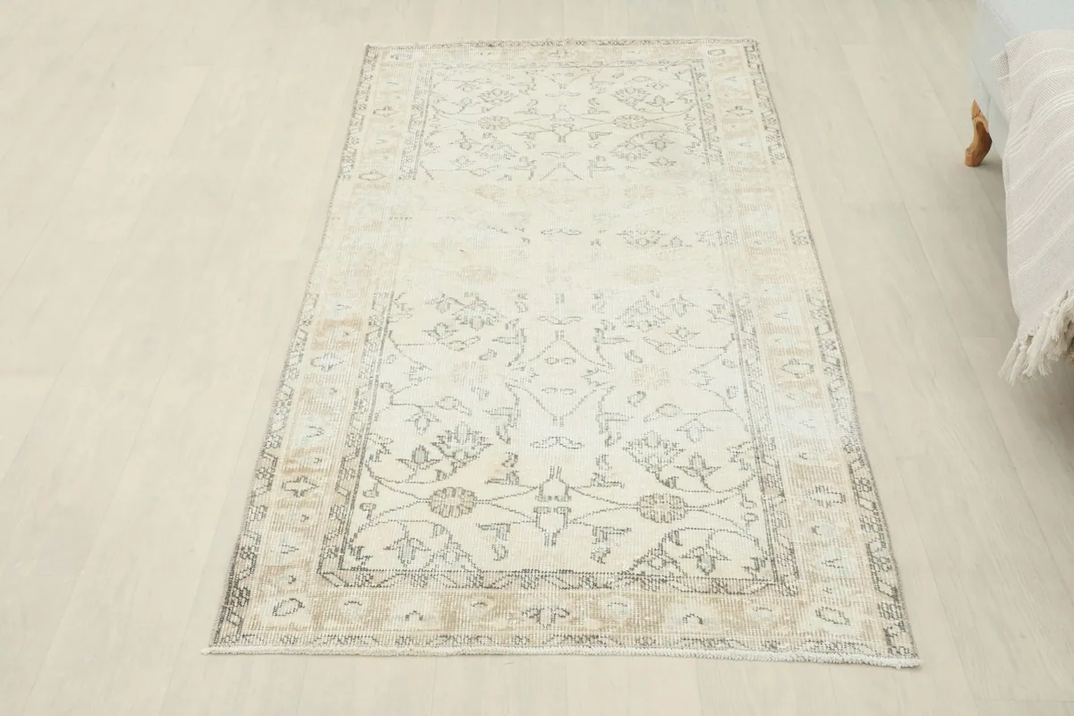 Full room view of the vintage ivory and tan rug, showcasing its rectangular shape and size
