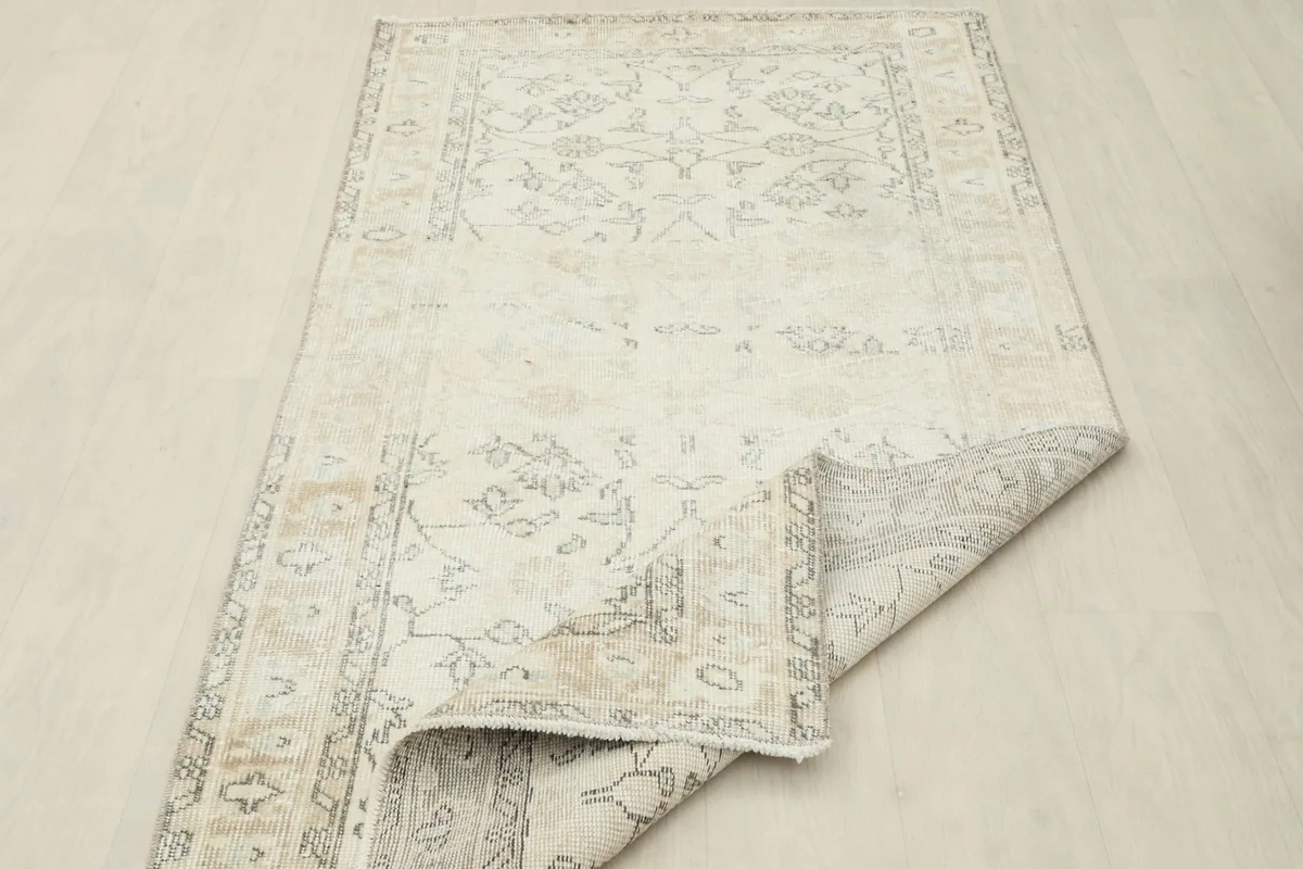 Side view of the rug with a section folded back, showing the back of the rug