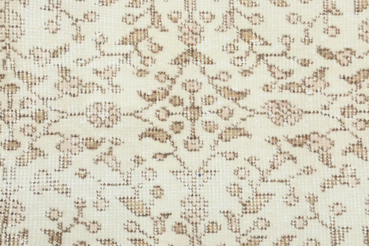 Macro view of the hand-knotted wool pile and intricate floral design elements