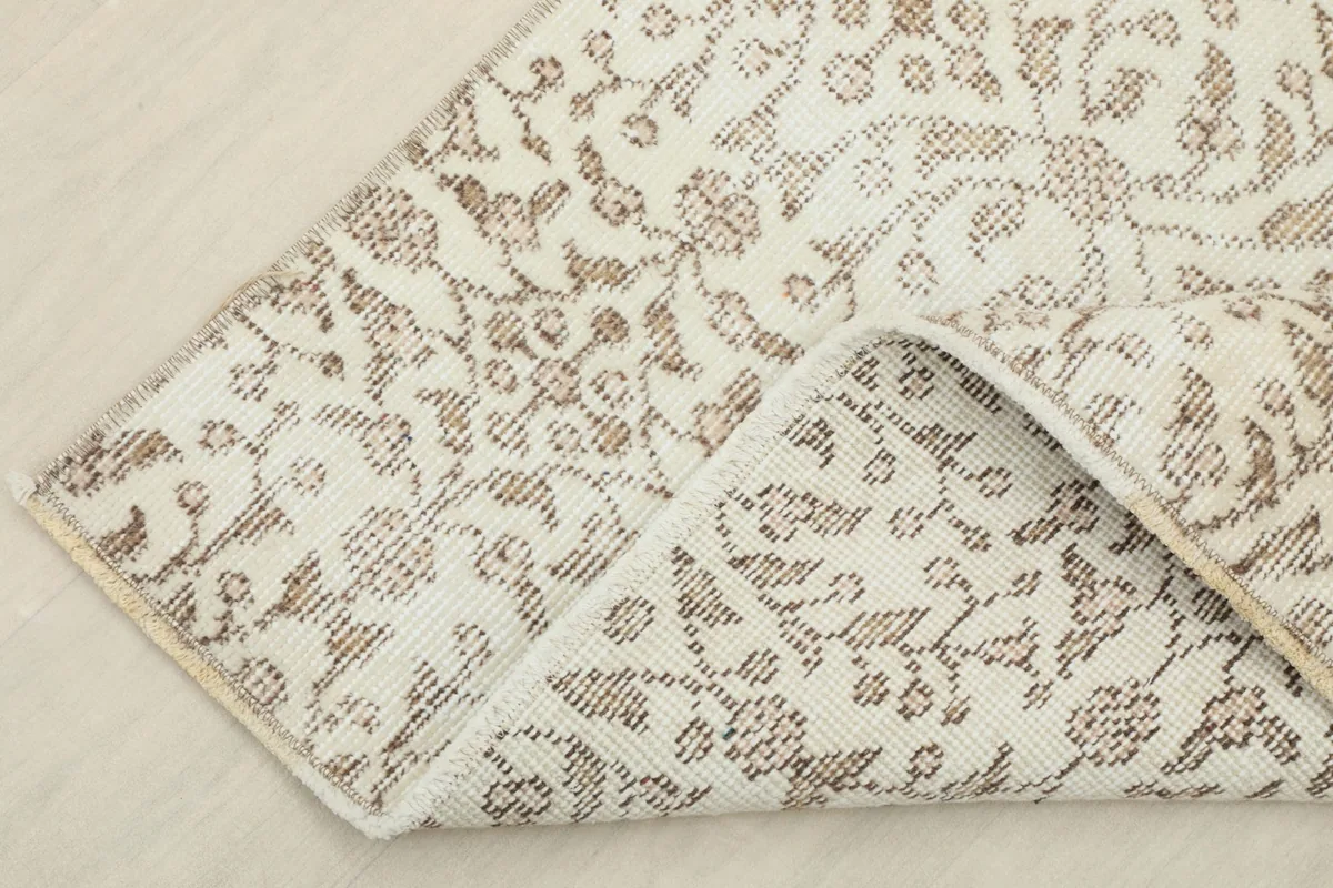 Folded corner of the rug, revealing the thickness and texture of the wool pile