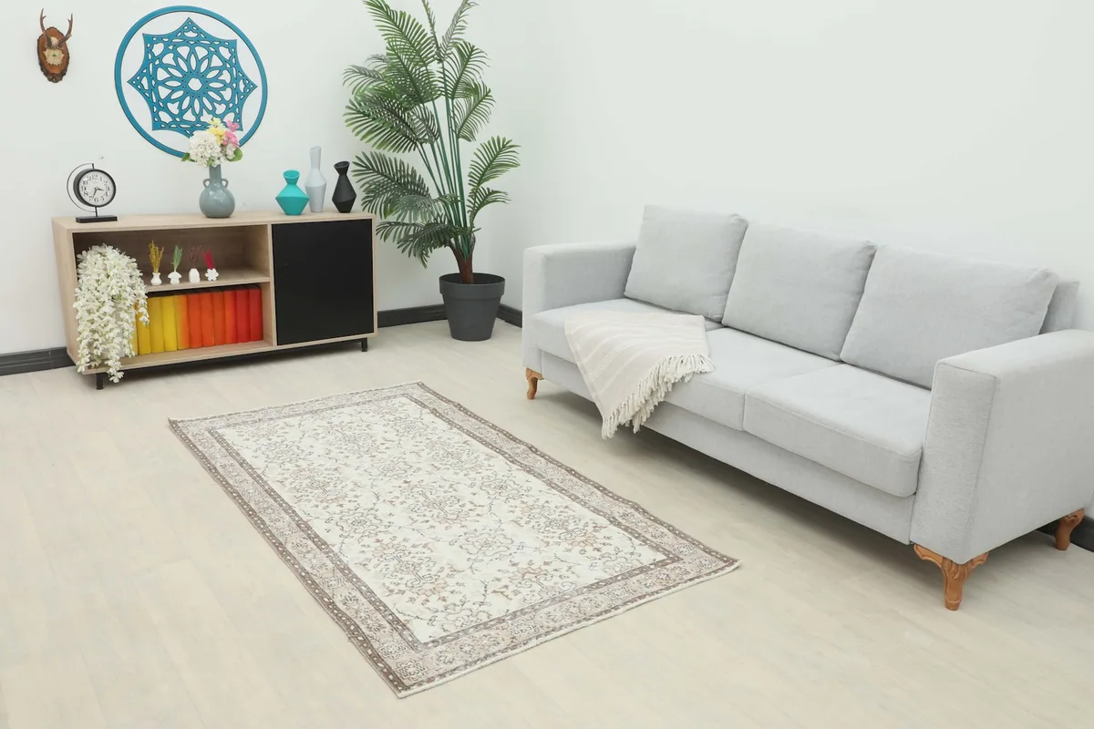 Ivory vintage rug displayed in a modern living room setting with a light gray sofa.