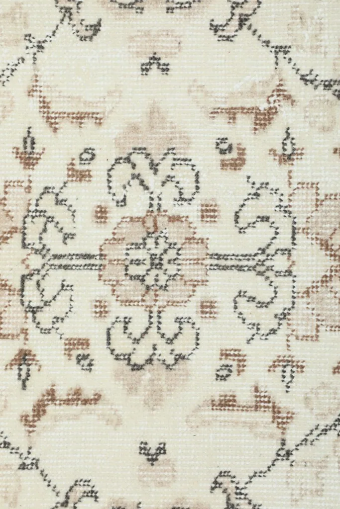 Detailed close-up of a central floral motif on the ivory field, showing the hand-knotted texture.