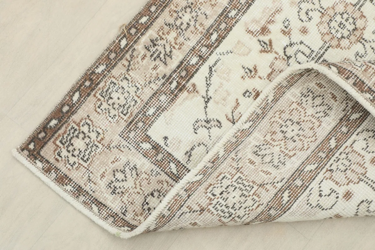 Detailed view of the rug's reverse side and a folded corner, showing the wool pile and cotton foundation.
