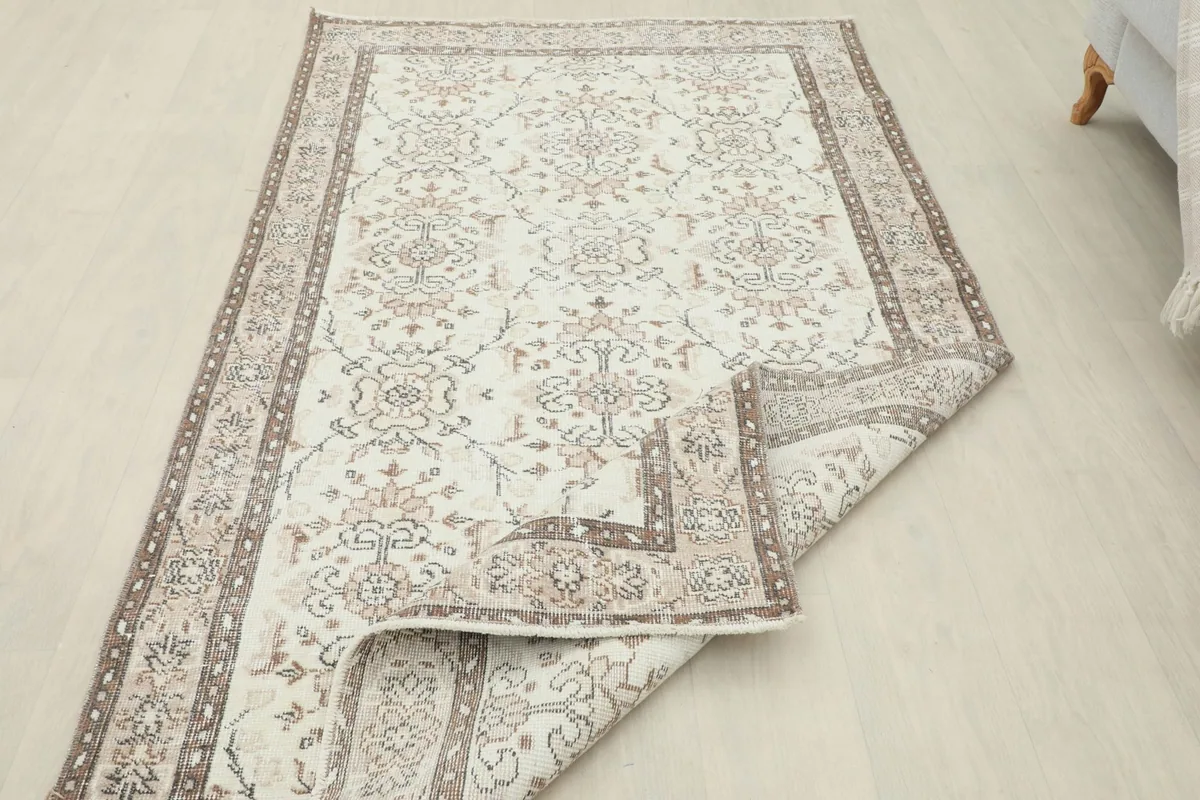 View of the rug with a corner folded back, revealing the reverse side and construction.