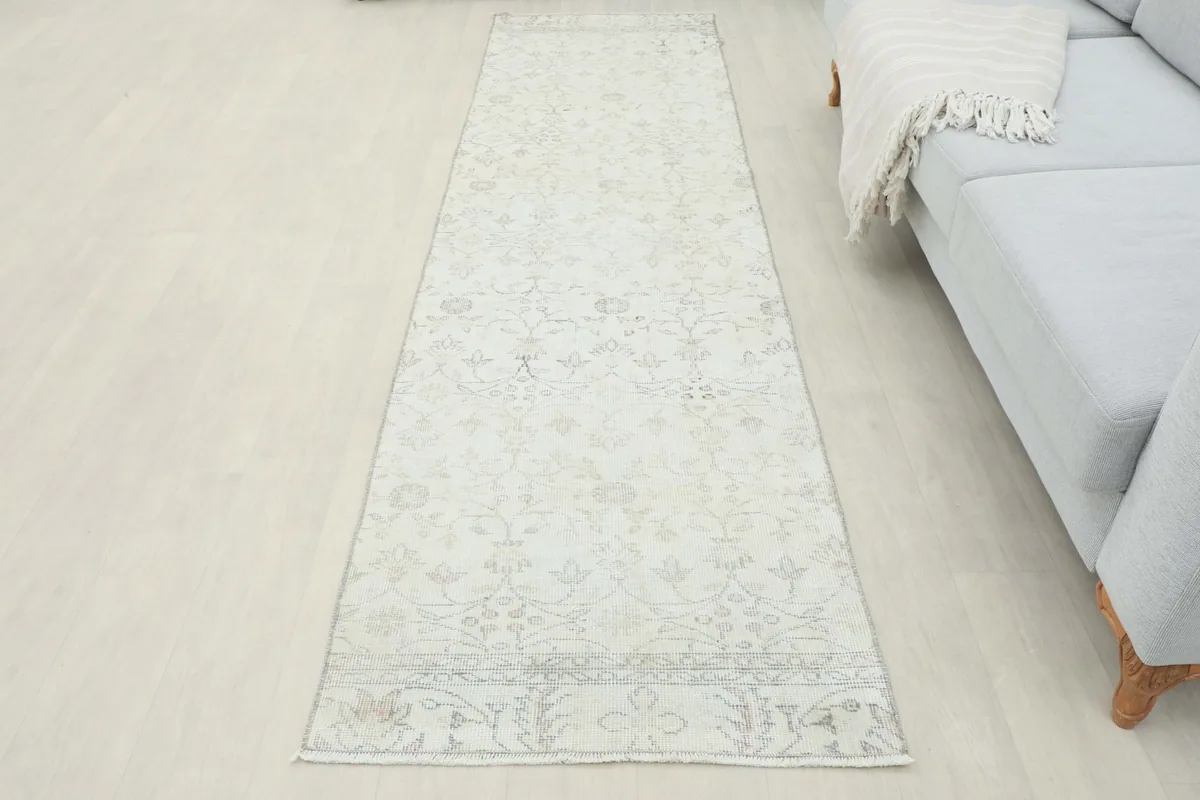 Full length view of the ivory runner rug in a room, emphasizing its long and narrow shape
