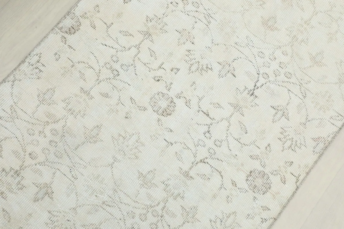 Close-up of the vintage wool pile, highlighting the delicate floral and vine patterns