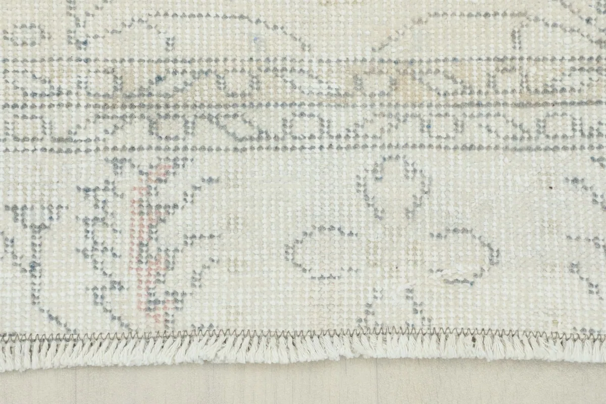 Detail of the short, natural cotton fringe and the edge of the hand-knotted wool pile