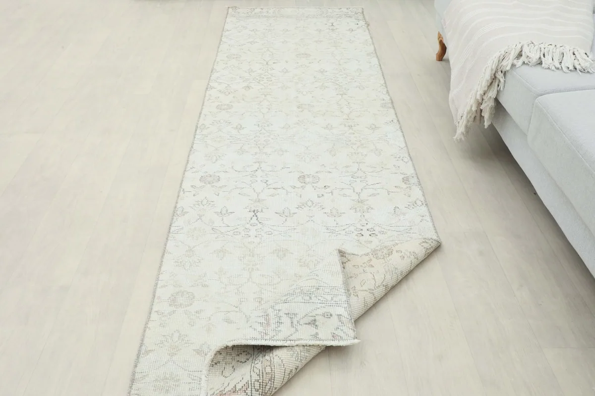 Runner rug partially folded, showing the flexibility and thickness of the vintage wool material