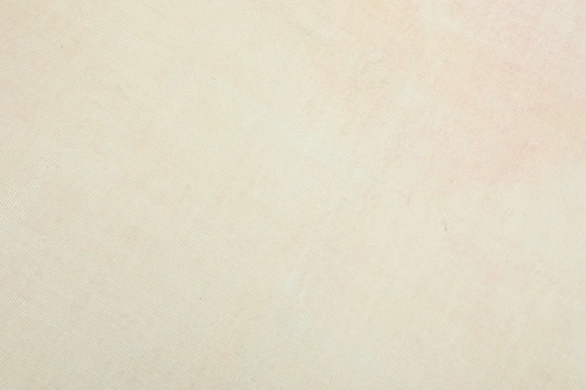 Detailed view of the wool pile, showing the gentle blend of cream and rose tones and soft texture