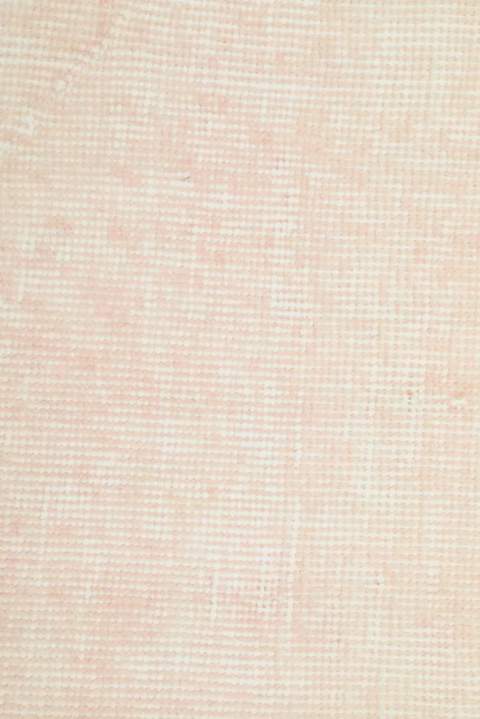 Close-up of the hand-knotted wool pile, revealing the weave and subtle color shifts of the vintage rug