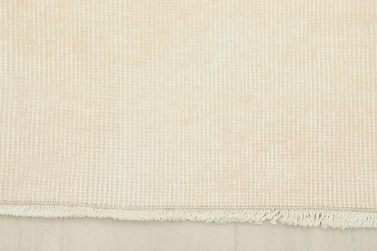 View of the rug's edge and short, natural cotton fringe, showing the clean finish