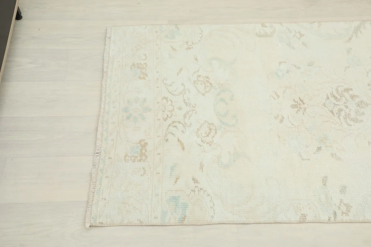 Overhead angle view of the rug's center with subtle floral and geometric designs