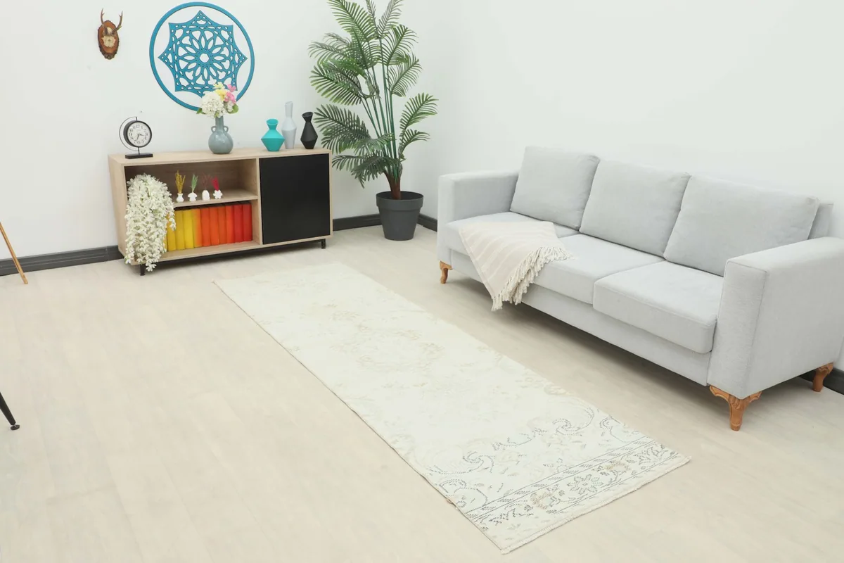 Ivory runner rug displayed in a living room setting, extending from a sofa