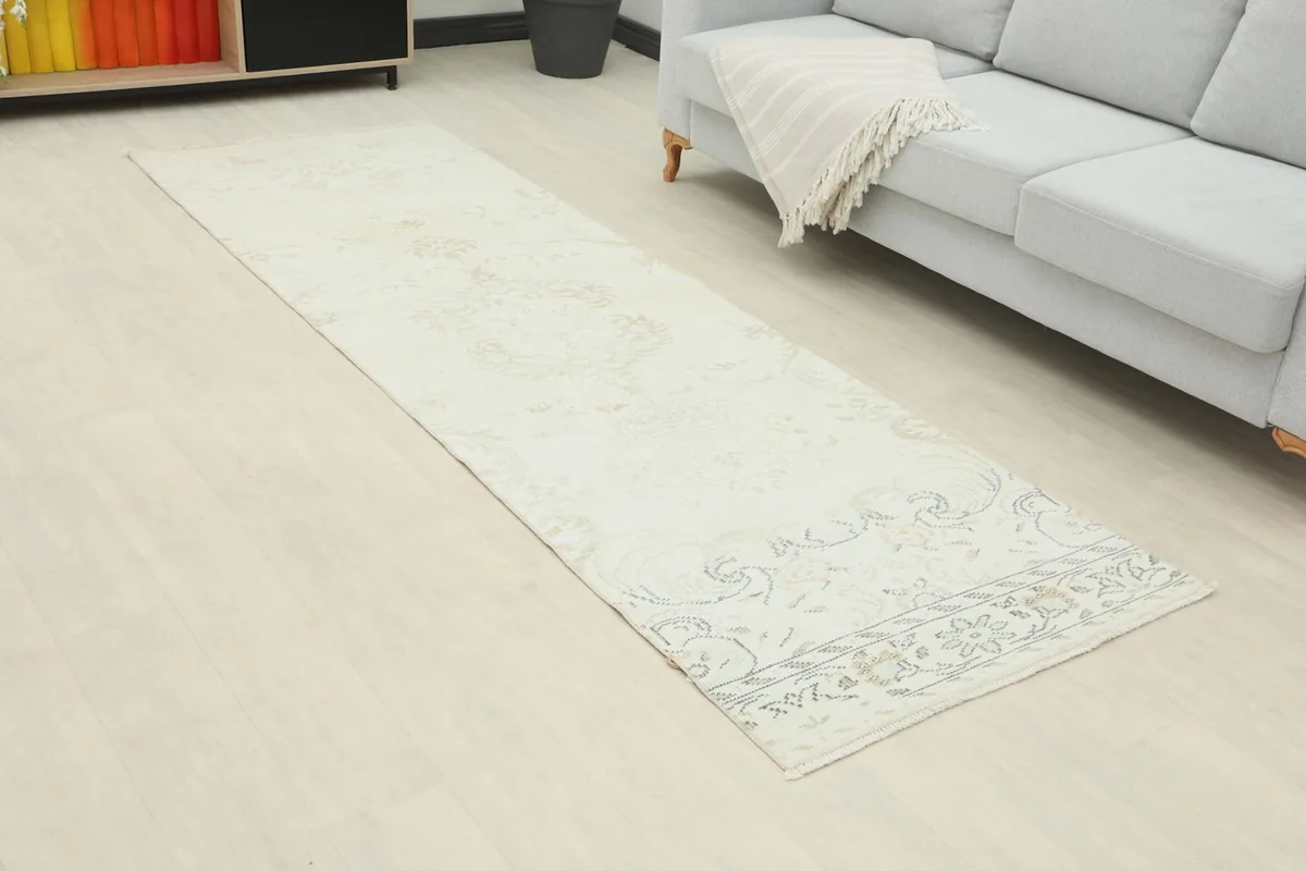 Long view of the ivory runner rug laid out in a room with light flooring
