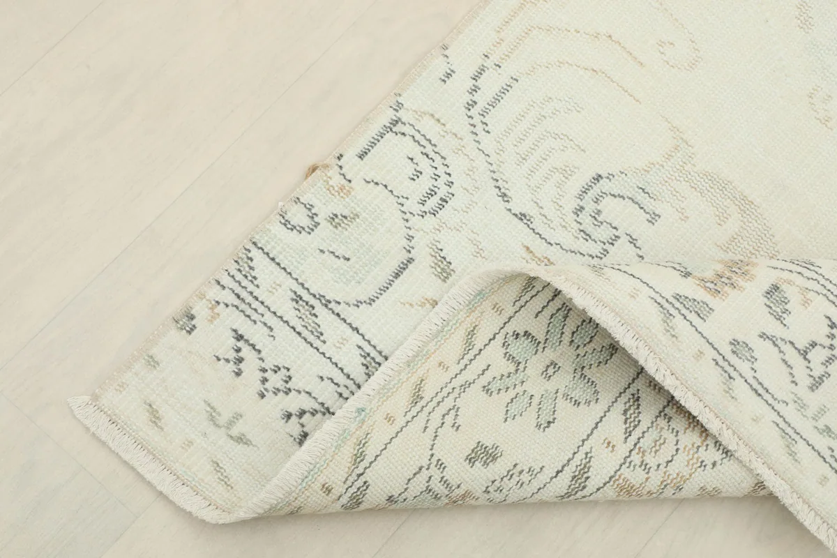 Corner of the rug folded to show the backing and the intricate weaving